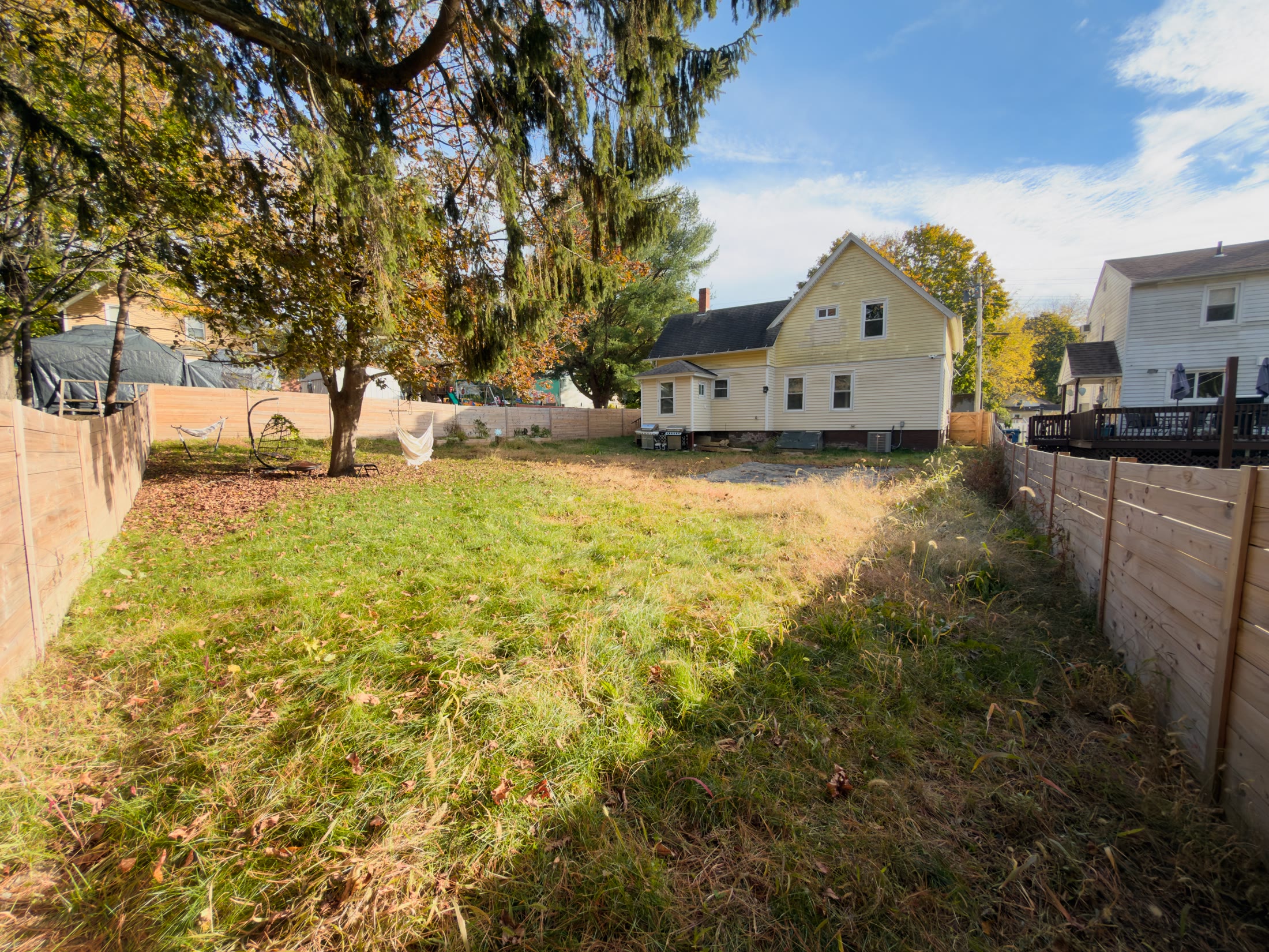 Fenced backyard with large tree